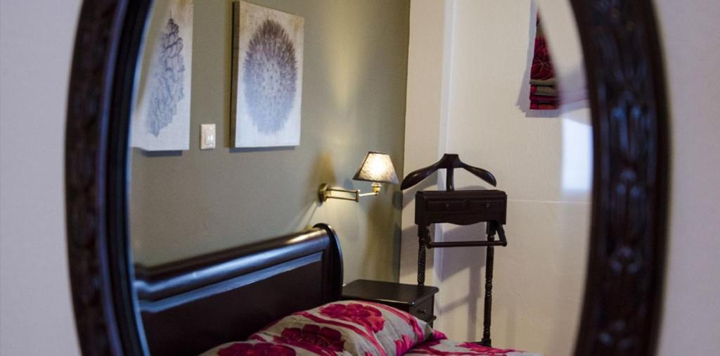 Dormitorio con espejo, cama y lámpara en Κleio Resort And Spa, en Amindeo