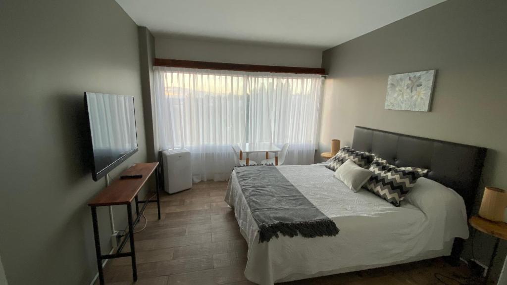 - une chambre avec un lit, un bureau et une fenêtre dans l'établissement Departamento céntrico con vista, à San Carlos de Bariloche