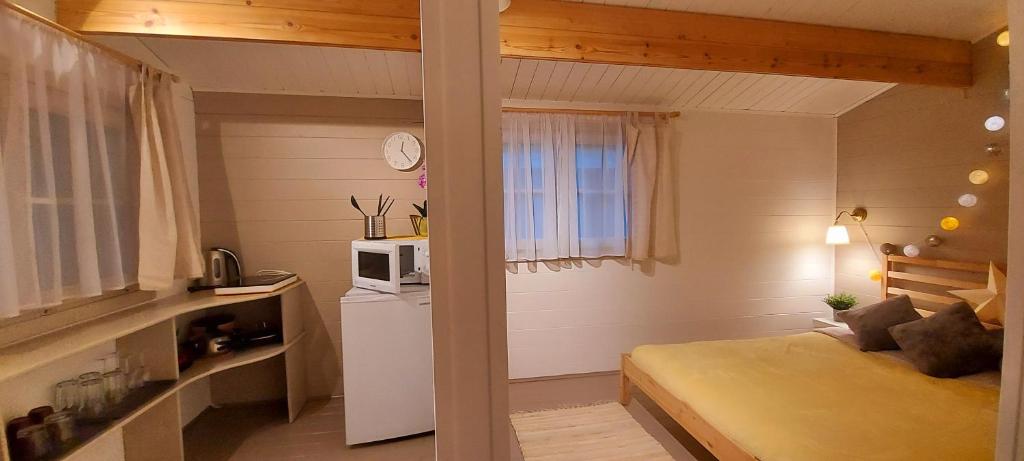 Habitación pequeña con cama y microondas. en Kempings Saulkrastos en Saulkrasti