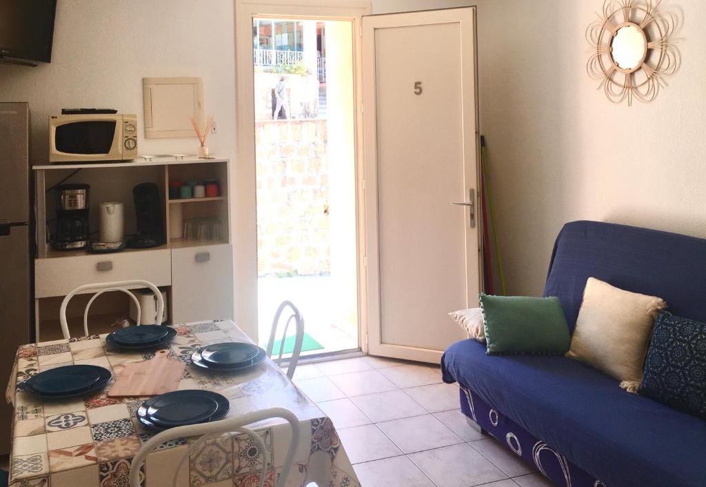 a living room with a table and a blue couch at Mare Nostrum in Porto Ota