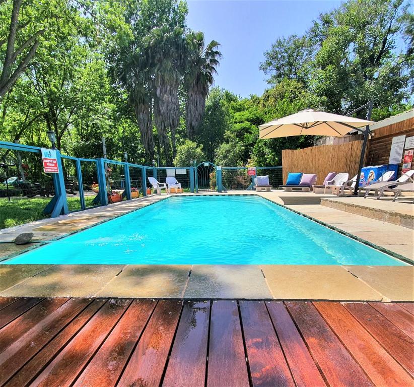 a large swimming pool with a wooden deck at Vitrage Holiday Village and Spa in Beit Hillel