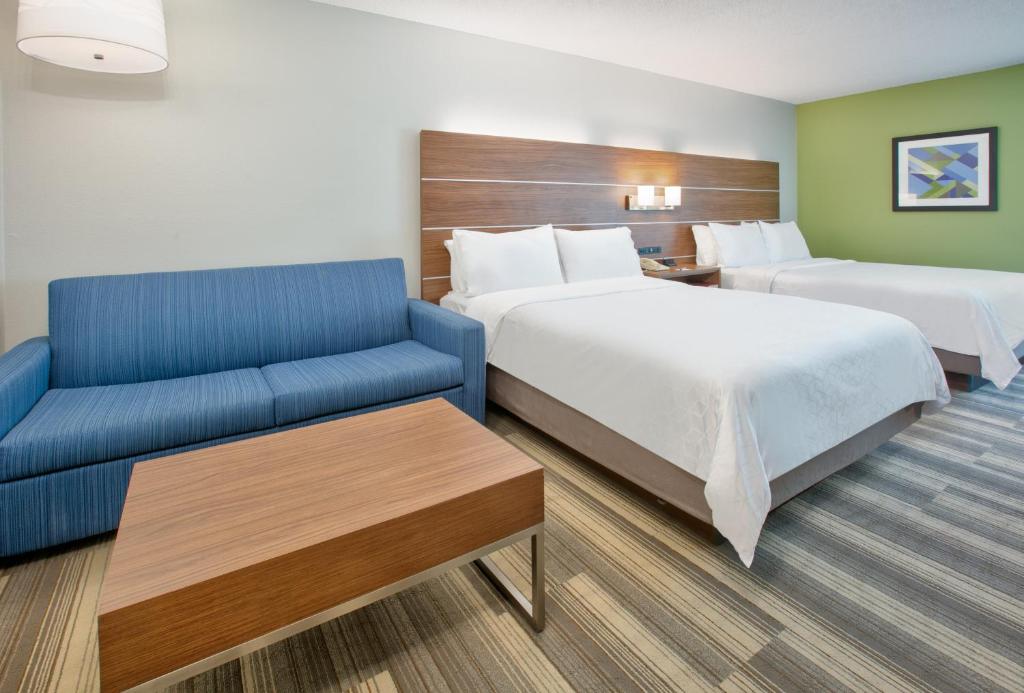 a hotel room with two beds and a blue couch at Holiday Inn Express - Hope by IHG in Hope