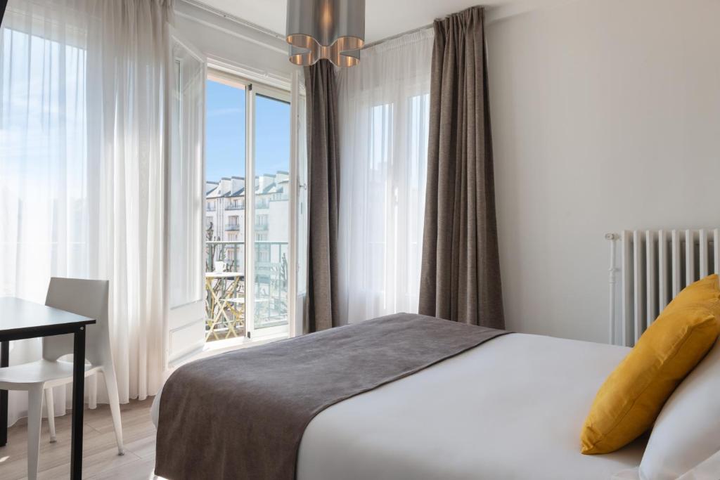 - une chambre avec un lit et une grande fenêtre dans l'établissement The Originals City, Hôtel Notre Dame, Rouen, à Rouen