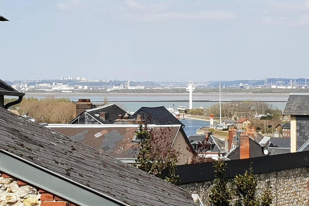 une vue d'une ville avec une rivière et des bâtiments dans l'établissement Le Longchamp, à Honfleur