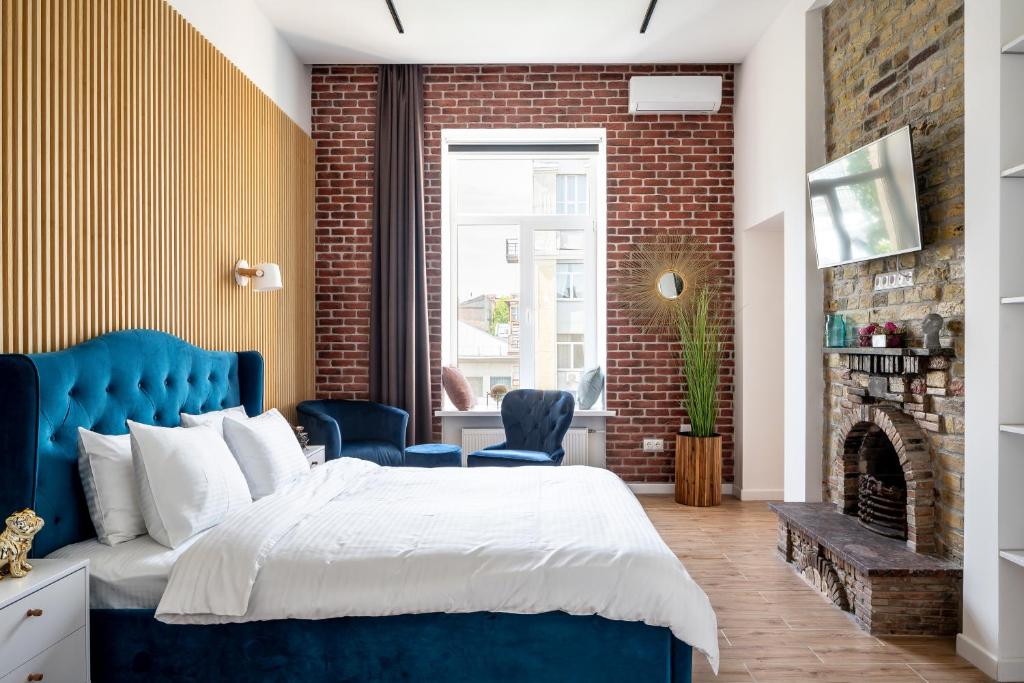 a bedroom with a blue bed and a brick wall at Proreznaya Apartments in Kyiv