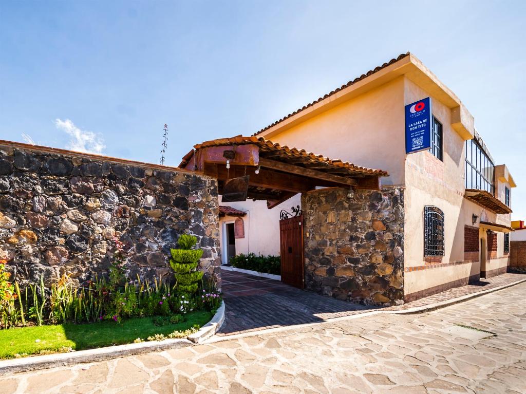 a building with a stone wall next to a street at Hotel La Casa Don Tito in Jocotitlán