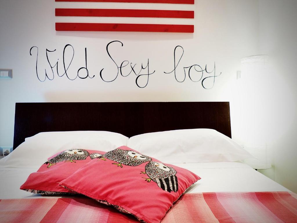 Una almohada roja en una cama con las palabras dirá alegría en DIMORA DEL MOLO ACQUARIO - GENOVABNB it, en Génova