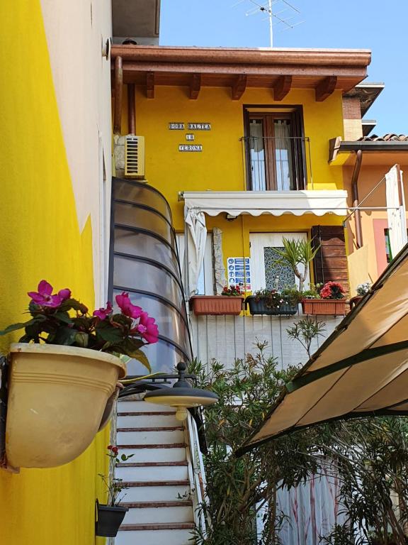 a yellow house with flowers on the side of it at Dora Baltea in Verona