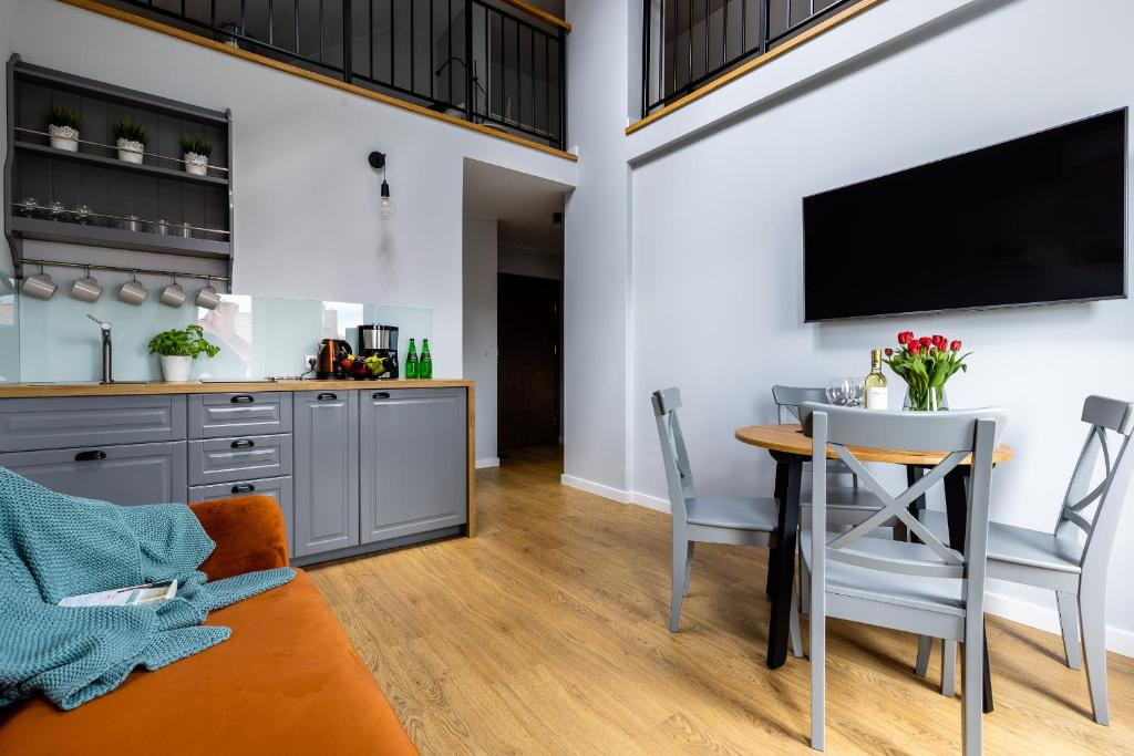 a kitchen and dining room with a table and chairs at Apartamenty na wydmach in Łeba