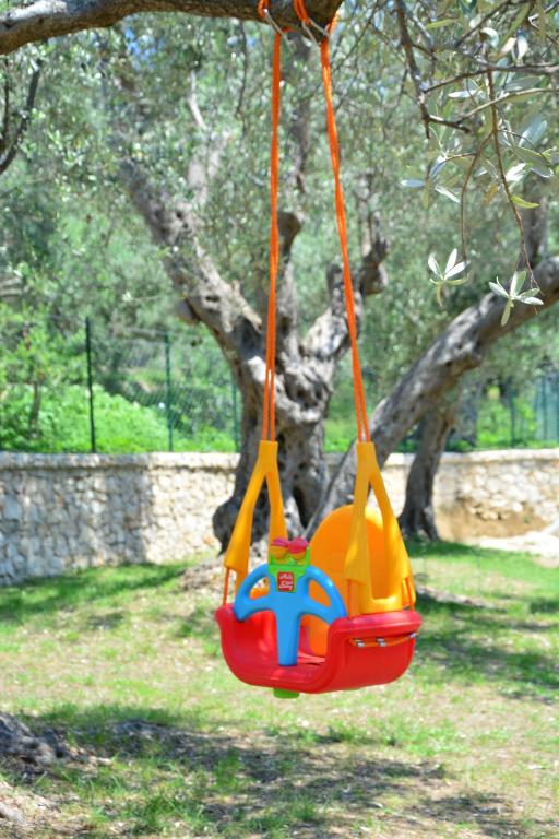 a toy swing hanging from a tree in a park at OLEA COTTAGE in Ulcinj