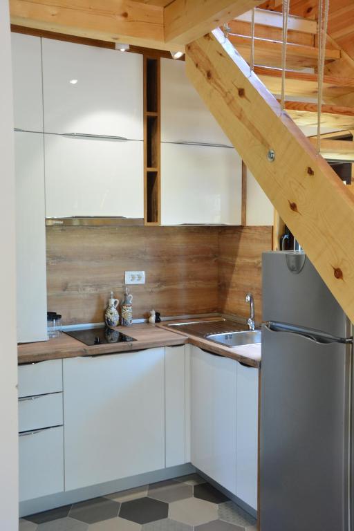 a kitchen with white cabinets and a stainless steel refrigerator at OLEA COTTAGE in Ulcinj