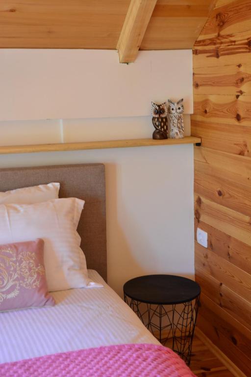 a bedroom with a bed and a wooden wall at OLEA COTTAGE in Ulcinj