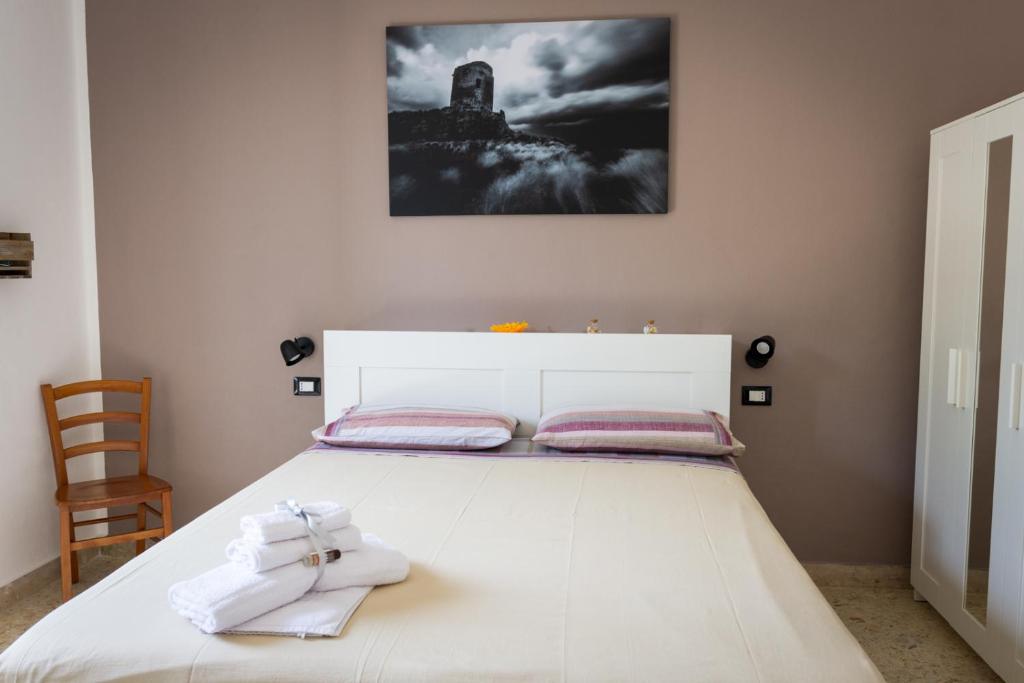 a white bed with two towels on top of it at La Casetta sul Mare in Isola delle Femmine