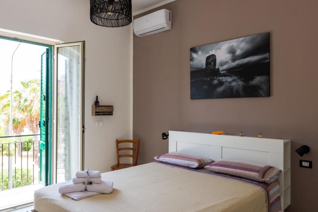 a bedroom with a bed and a large window at La Casetta sul Mare in Isola delle Femmine