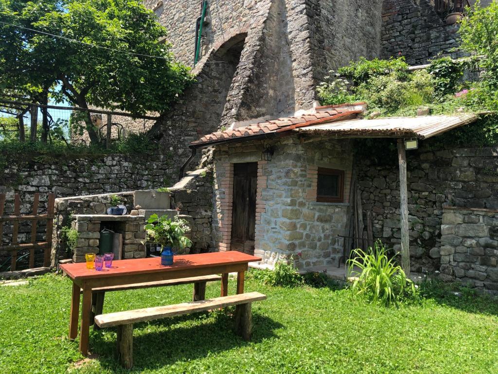 - une table de pique-nique devant un bâtiment en pierre dans l'établissement Casa sulla Valle, à Castelvecchio