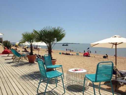 een groep stoelen en een parasol op een strand bij studio presqu'île Fouras proche de la plage parking privé in Fouras