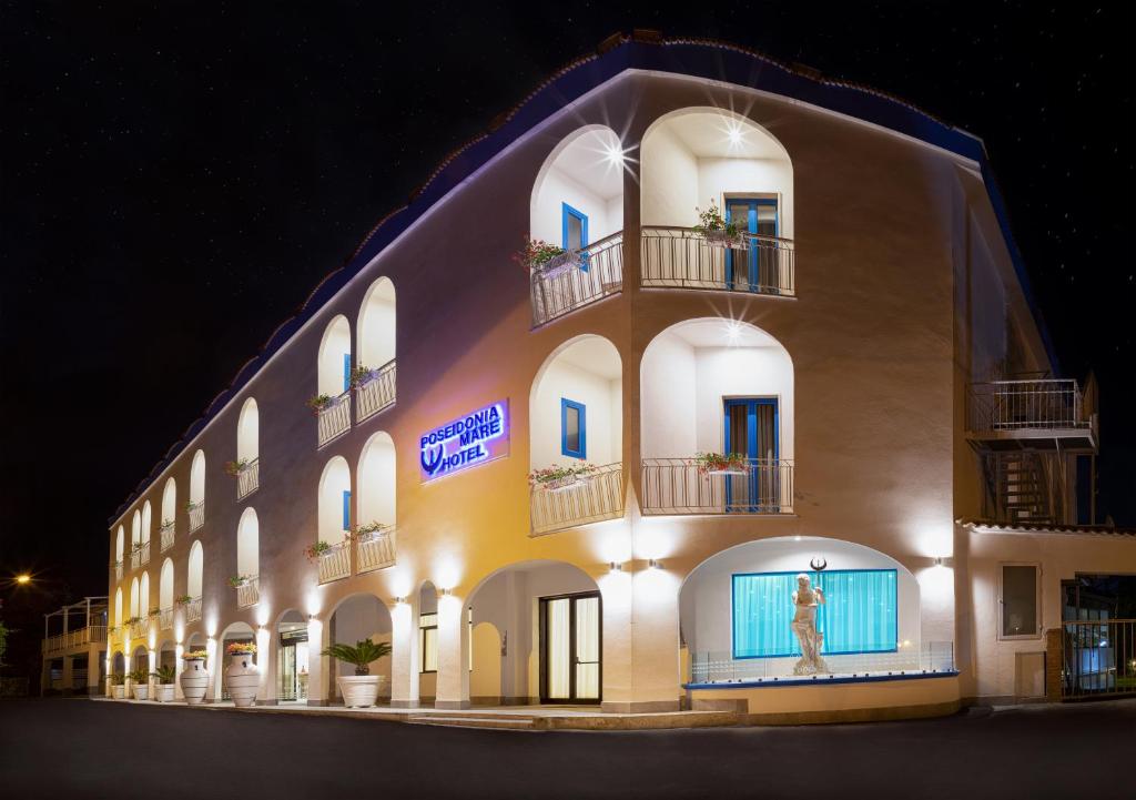 a large building with a sign on it at night at Hotel Poseidonia Mare in Paestum