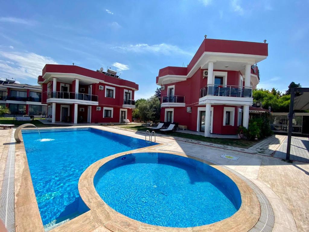 a villa with a swimming pool in front of a house at Cilek Butik Hotel in Çeşme