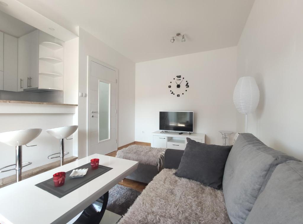 uma sala de estar com um sofá e uma mesa em Deluxe apartment Sunrise Trebinje em Trebinje