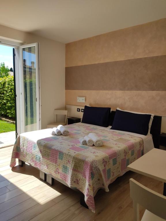 sypialnia z łóżkiem z ręcznikami w obiekcie Casa Pepe w mieście Colà di Lazise