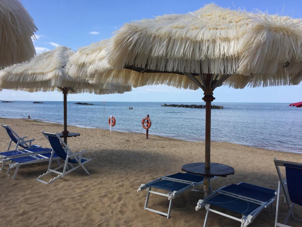 un gruppo di sedie e ombrelloni in spiaggia di Hotel Mare Blu a Francavilla al Mare