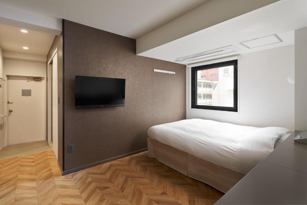 Tempat tidur dalam kamar di Shinjuku City Hotel N.U.T.S Tokyo