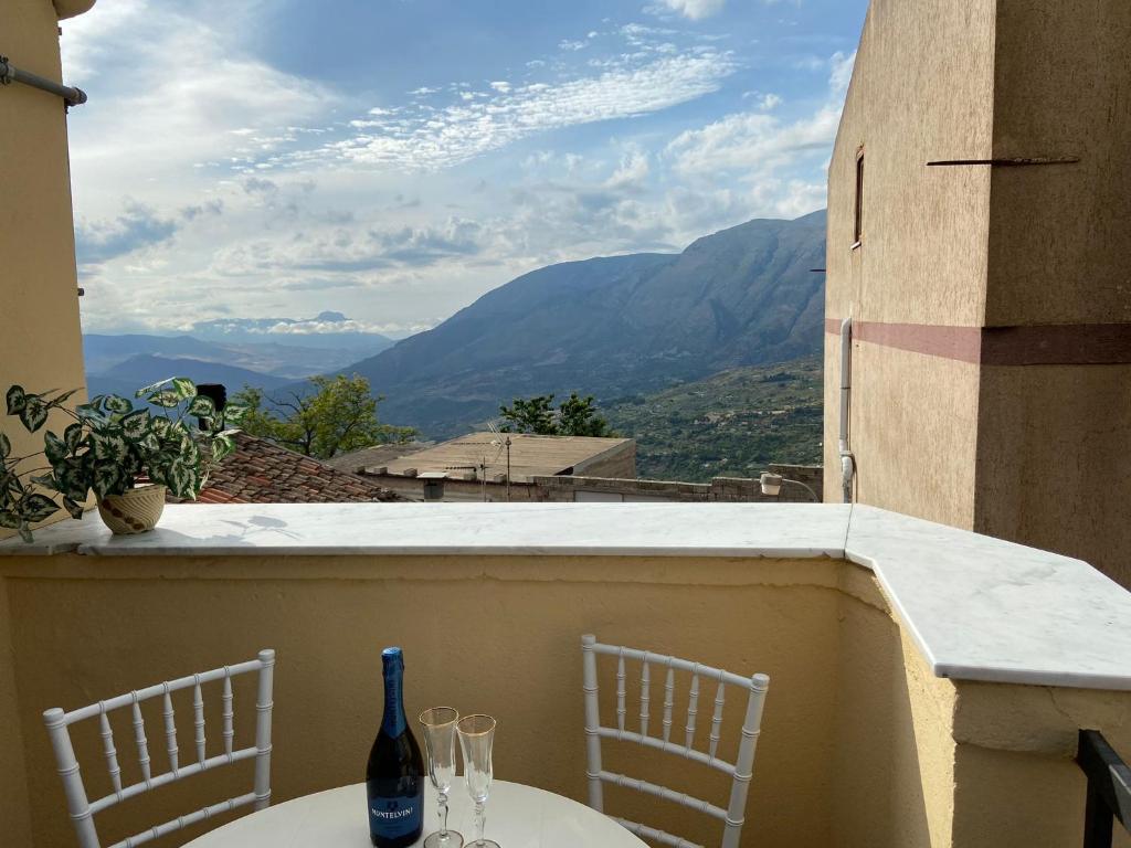 a balcony with two tables and two bottles and chairs at Affittacamere La Casa Dei Nonni in Polizzi Generosa