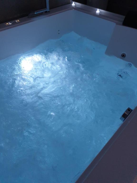 a large pool of blue water in a room at Elle & Lui en Jacuzzi in Bernis