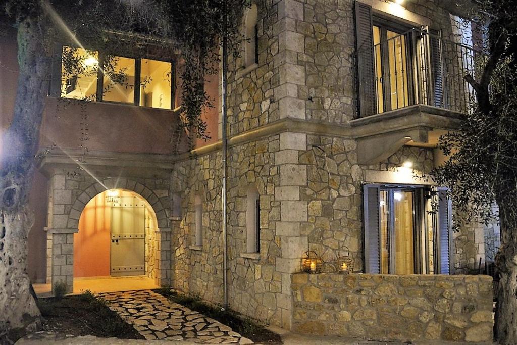 una casa de piedra por la noche con la puerta abierta en PargaMondo Countryliving en Parga