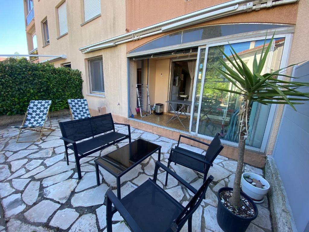 a patio with chairs and a table and a potted plant at Boost Your Immo Six Fours Les Plages Le Marie Louise 485 in Six-Fours-les-Plages