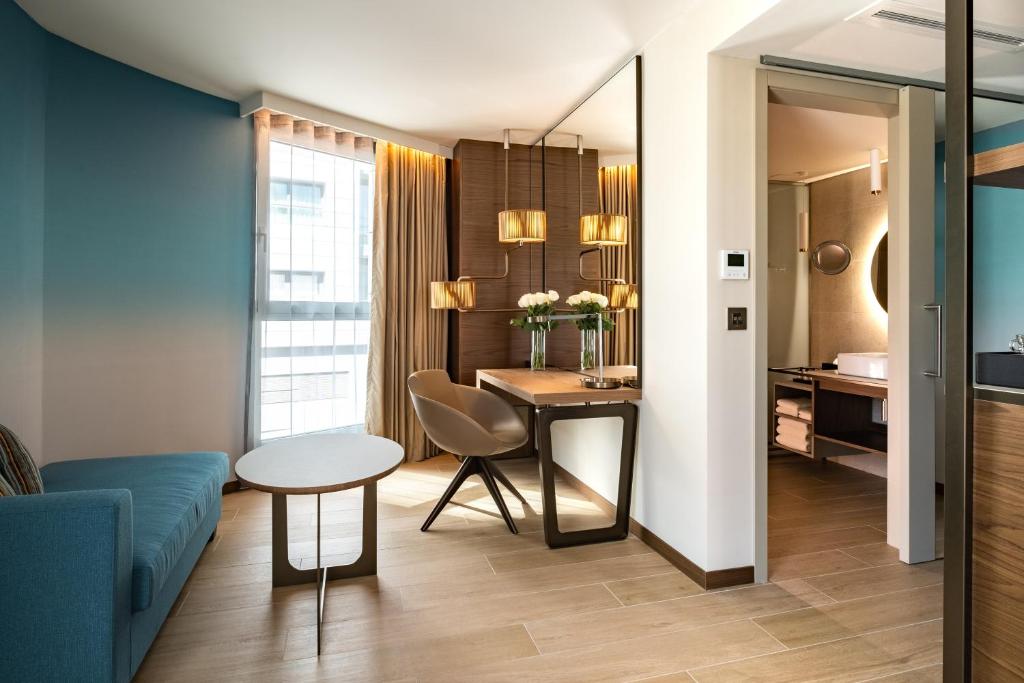 a living room with a blue couch and a table at Hyatt Regency Malta in St. Julianʼs