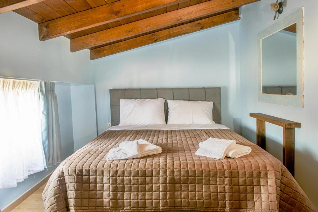 ein Schlafzimmer mit einem Bett mit zwei Handtüchern darauf in der Unterkunft 3D iliadis Suites in Ierissós
