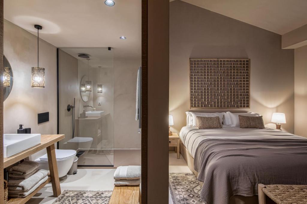 a bedroom with a large bed and a bathroom at Terra Rosa Country House & Vineyards in Ponte de Lima