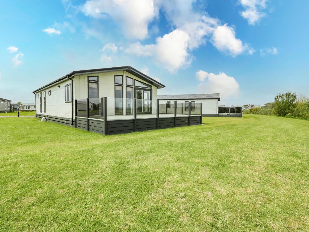 una casa modular con un gran patio de césped en Fairway View 24, en Burnham-on-Sea