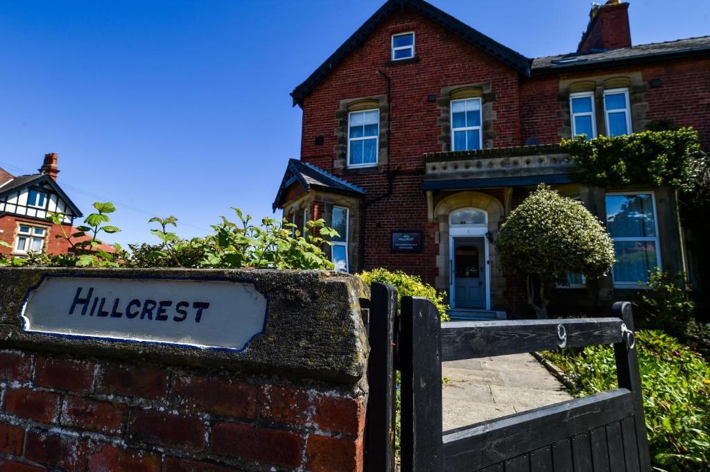 een stenen huis met een bord ervoor bij Hillcrest Whitby in Whitby