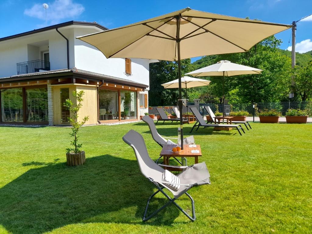 ein paar Stühle und ein Regenschirm in einem Hof in der Unterkunft Miravallesuites in San Zeno di Montagna