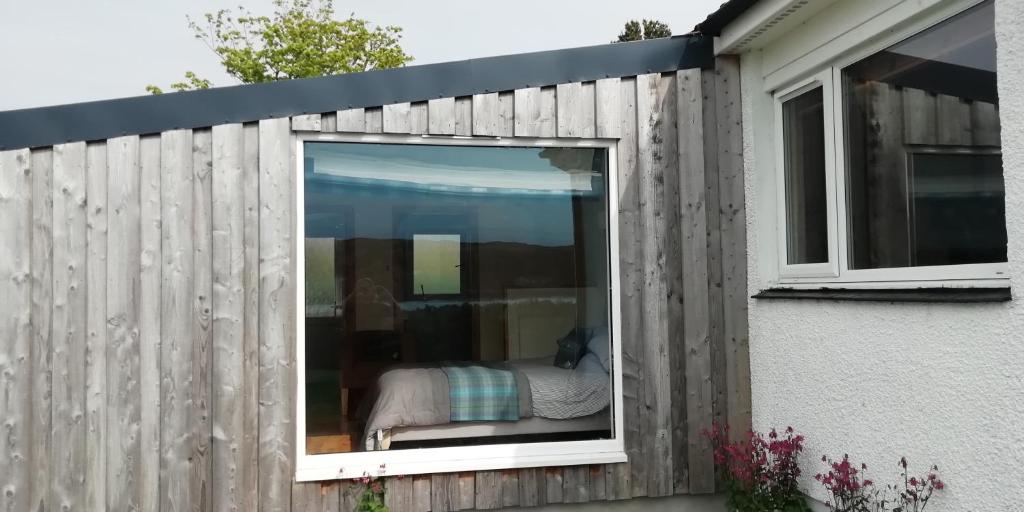 ein Schlafzimmer, das durch ein Fenster eines Hauses gesehen wird in der Unterkunft Kiloran Self Catering Suite in Skeabost
