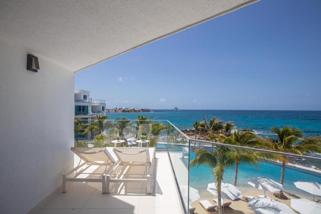 a balcony with chairs and a view of the ocean at The Morgan Resort Spa & Village in Simpson Bay