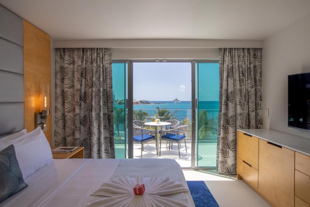 a bedroom with a bed and a view of the ocean at The Morgan Resort Spa & Village in Simpson Bay