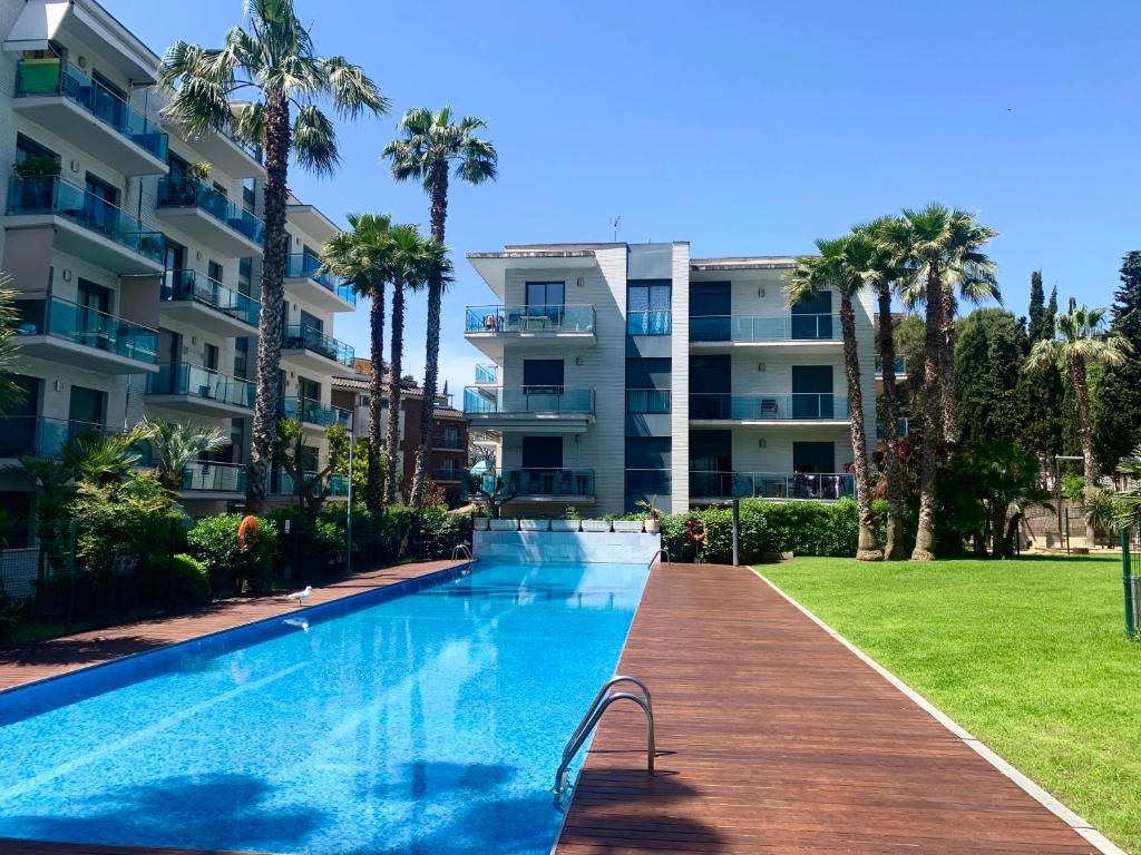 a swimming pool in front of a building at Apartamentos Jardín Turquesa in Lloret de Mar