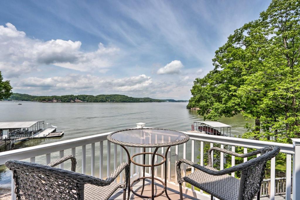 a balcony with a table and chairs and a view of the water at Sunny Providence Cottage Retreat with Dock, Kayaks in Sunrise Beach