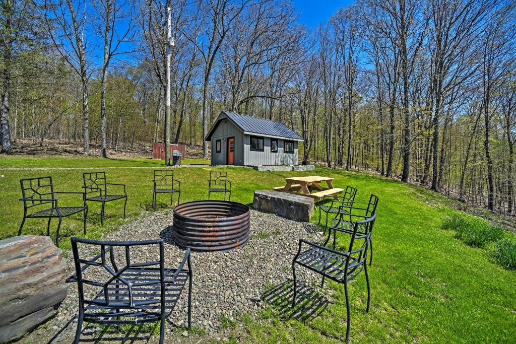 a group of chairs and a picnic table in a field at Cozy Hillside Retreat with BBQ, Fire Pit, and Trails! in Milford