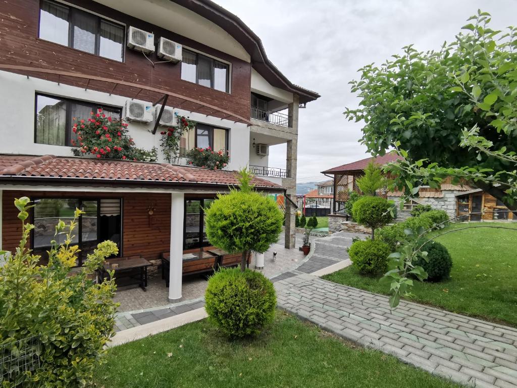 una casa con un jardín delante de ella en Hotel My House, en Kardzhali