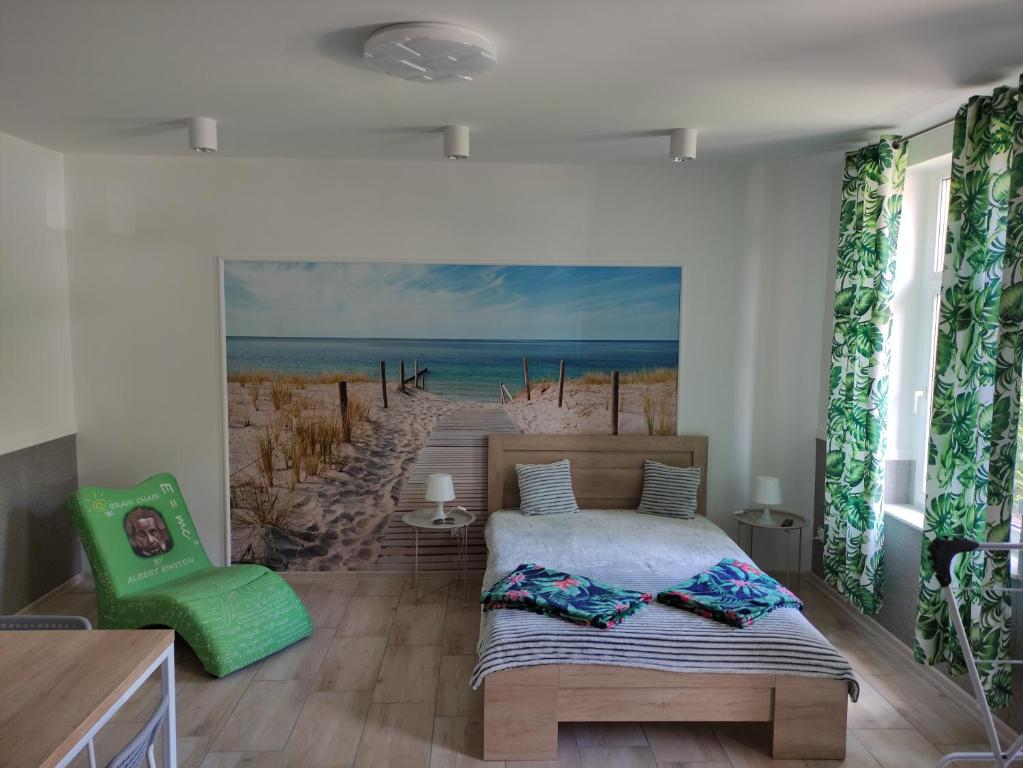 sypialnia z łóżkiem i obrazem plaży w obiekcie Apartamenty Bulwar Nadmorski, Ustka w Ustce