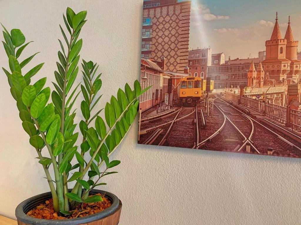 a plant in a pot next to a painting on a wall at Rest Point Sampran in Nakhon Pathom