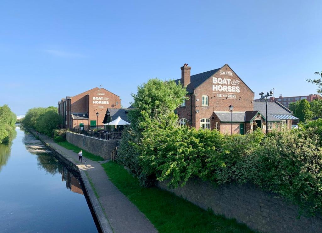 um edifício ao lado de um rio ao lado de um edifício em Boat & Horses Inn em Oldham