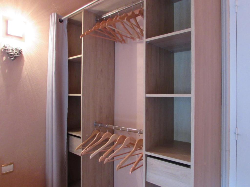 a walk in closet with wooden shelves and hangers at Résidence Royal Palmeraie in Aubagne