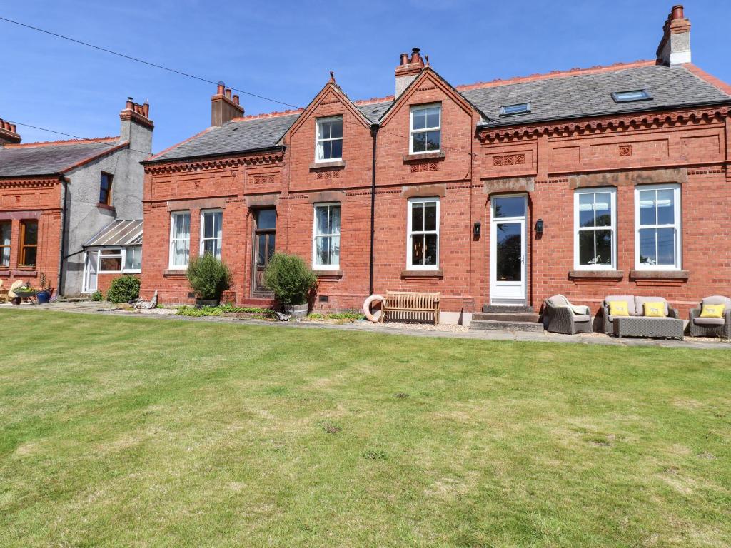 a brick house with a lawn in front of it at Seascape in Annan