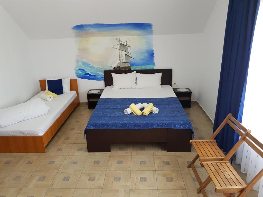 a bedroom with a bed and a painting of a ship at EL Capitano - Mamaia Nord in Mamaia Nord