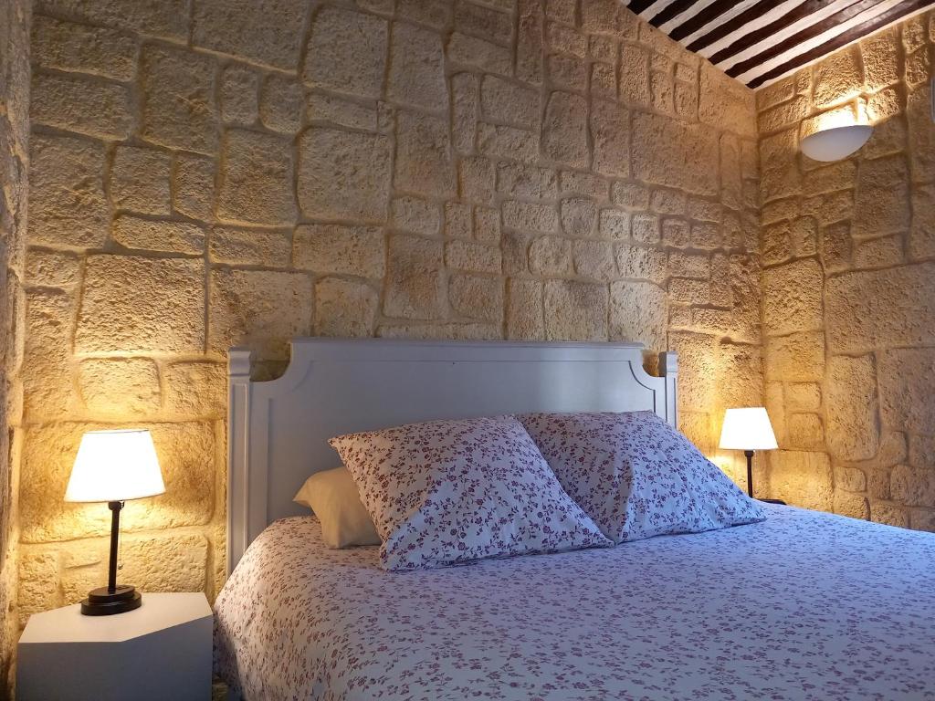 a bedroom with a bed with a stone wall at Résidence Royal Palmeraie in Aubagne